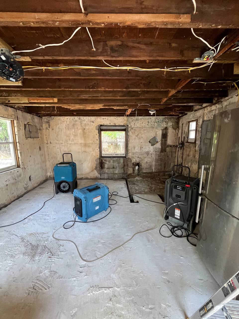 Structural drying setup with exposed original ceiling joists and air movers